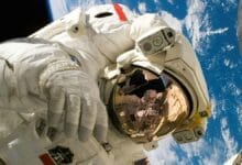 رائد فضاء يرتدي بدلة فضائية أثناء مهمة خارج المركبة الفضائية مع كوكب الأرض في الخلفية