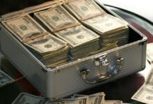 حقيبة آمنة مليئة برزم من الأموال تمثل الثروة والنجاح المالي والسعي نحو الثراء من الصفر.