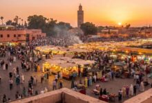 مشهد بانورامي لساحة جامع الفناء النابضة بالحياة في مراكش عند الغروب