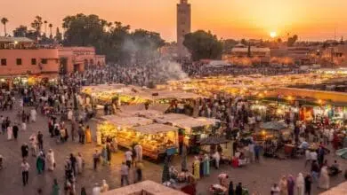 مشهد بانورامي لساحة جامع الفناء النابضة بالحياة في مراكش عند الغروب